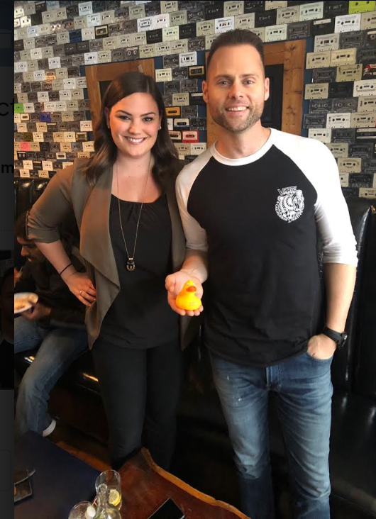 two people posing with a rubber duck